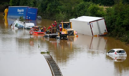 Miembros de un equipo de rescate trabajan junto a coches atascados en la carretera tras las fuertes lluvias en Erftstadt, Alemania.