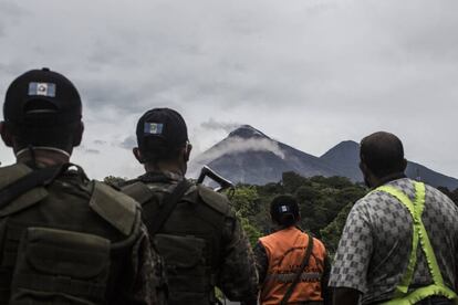 Elementos del ejército y rescatistas observan el volcán de Fuego tras una de sus exhalaciones, hasta el momento continua la alerta permanente.
