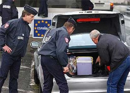 Dos policías franceses controlan el maletero de un coche en la frontera con España en Biriatou.