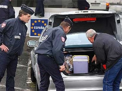 Dos policías franceses controlan el maletero de un coche en la frontera con España en Biriatou.