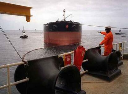 Un operario de Total señala hacia un buque de carga español en la plataforma petrolífera Girassol, en la costa angoleña.