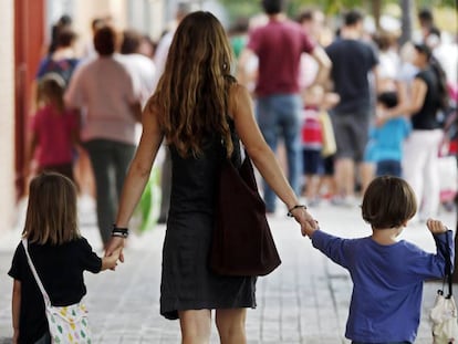 Uma mãe leva a seus filhos ao colégio.