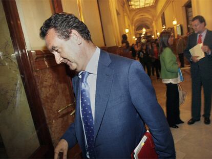 El diputado del PP Jesús Merino, en un pasillo del Congreso. A la derecha, Mariano Rajoy y Ana Mato.