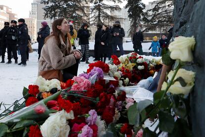 Una mujer se sienta frente al monumento a las víctimas de la represión política de Moscú, en honor a la muerte del activista Alexei Navalny, este sábado.  