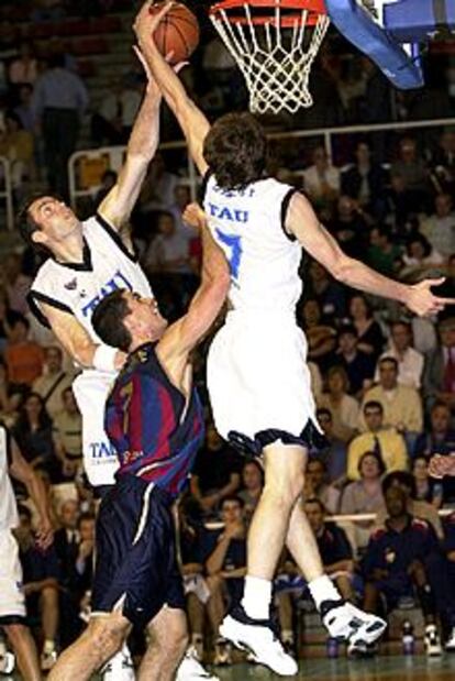 El jugador del Barcelona De la Fuente intenta llegar al balón entre dos jugadores del Tau.