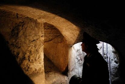 Un policía italiano ilumina con una linterna una pared de un mausoleo del siglo II d. C., cuyo acceso estaba oculto bajo la basura de un vertedero ilegal en Nápoles. (FOTOS: CIRO DE LUCA, AGN FOTO)