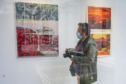 Un hombre sostiene una cámara para fotografiar una de las obras que componen la presentación de la exposición Itinérance en la Casa de Velázquez.