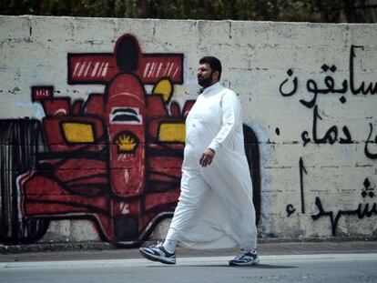 Un hombre pasa junto a una pintada en la ciudad de Barbar contra la celebraci&oacute;n del GP de Bahr&eacute;in
 