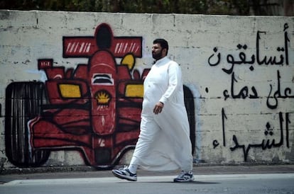 Un hombre pasa junto a una pintada en la ciudad de Barbar contra la celebraci&oacute;n del GP de Bahr&eacute;in
 