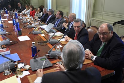 El presidente del Poder Judicial y del Tribunal Supremo, Carlos Dívar (de espalda), al inicio de la reunión del pleno extraordinario del Consejo General del Poder Judicial (CGPJ) que ha decidido suspender cautelarmente al juez de la Audiencia Nacional Baltasar Garzón.