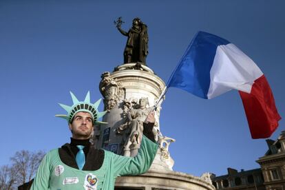 Fantasiado de estátua da liberdade, homem segura uma bandeira da França