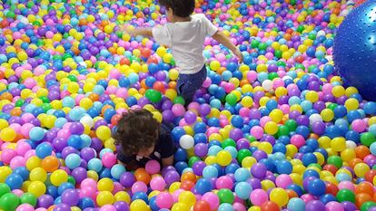 Dos niños en una piscina de bolas.