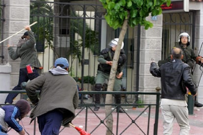 Un grupo de manifestantes se enfrenta con la policía en una marcha contra la guerra, en Atenas.