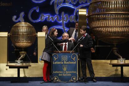 Los niños de San Ildefonso Isaac Patricio Vaquero y Nazaret Blanco Carrizal muestran el quinto premio (el 18102) al responsable de la mesa, en 2015.