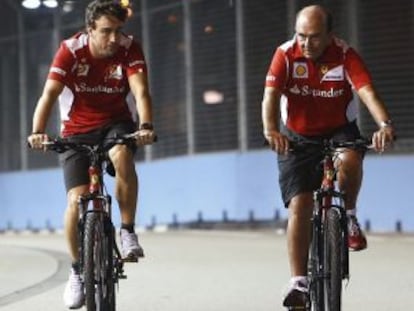 Fernando Alonso y Emilio Bot&iacute;n, recorriendo en bici el circuito de Singapur.