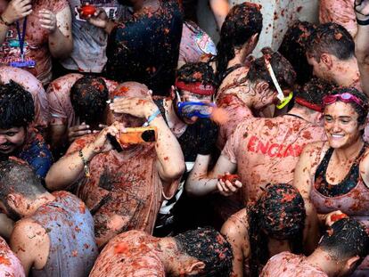 A man takes a photo in the midst of the crowds at Tomatina 2018.