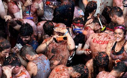 A man takes a photo in the midst of the crowds at Tomatina 2018.