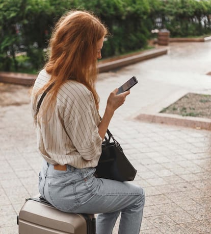 Chica utilizando un smartphone de vacaciones