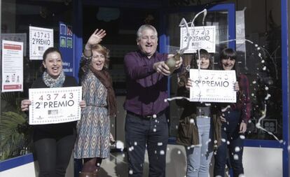 Manuel García Ortín (3i), gerente de la administración de lotería número uno de Bullas (Murcia), junto a la vendedora de la administración Ana López (izquierda) celebran que han despachado cinco series del número 43743, segundo premio de la lotería de El Niño que ha dejado en el municipio 3.750.000 euros.