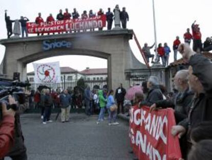 Los trabajadores de Sniace, encerrados en la fábrica, reciben subidos en el arco de entrada a la manifestación que han protagonizado sus compañeros desde Torrelavega hasta la factoría para pedir la continuidad de la actividad de la empresa, que despidió en septiembre pasado a toda la plantilla.