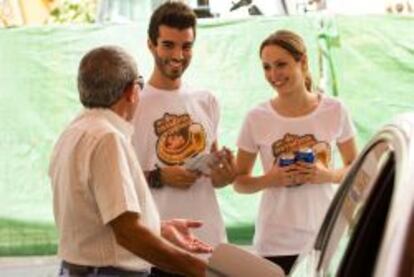 Participantes en la campaña En la carretera, cerveza sin de 2013 conversan con un conductor.