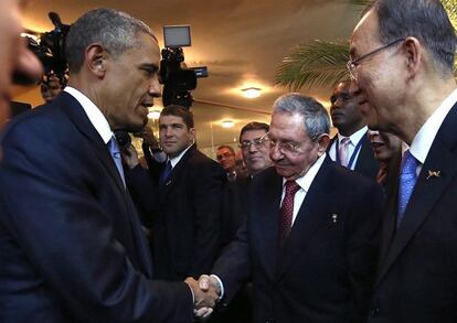 Barack Obama greets Raúl Castro.