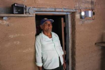 Juan Hernández, poblador de la comunidad de Xicalpestle, en Oaxaca, posa a la entrada de su casa, donde fue instalado un sistema de energía solar.