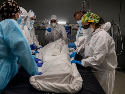 Reportaje sobre el Hospital de pandemias destinado a pacientes COVID-19  Isabel Zendal de Madrid. En la imagen, varios sanitarios manipulan a un paciente en una UCI.  FOTO: Carlos Rosillo.