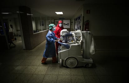 Dos sanitarias trasladan un equipo portátil de radiología por una de las plantas destinadas a UCI del hospital. Los equipos de radiodiagnóstico son fundamentales para el tratamiento de la enfermedad ya que permiten evaluar el daño pulmonar, donde se ceba el coronavirus. En el Marañón, en enero, se hicieron 4.053 placas de tórax. En marzo se han hecho 10.496.