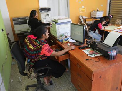 Una mujer trabaja con su bebé en la espalda en Cajolá, Guatemala.