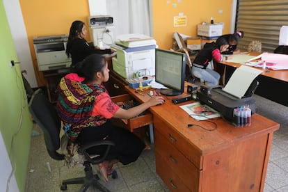 Una mujer trabaja con su bebé en la espalda en Cajolá, Guatemala.