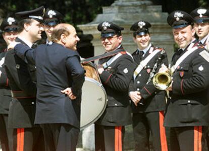 Berlusconi charla con la banda de Carabineros mientras espera la llegada del presidente checo en visita oficial. / EPA