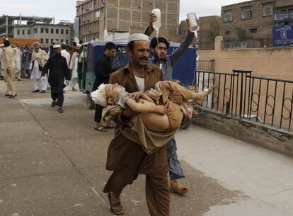 Un hombre se dirige a un hospital de Peshawar (Pakistán) con un niño en brazos, herido en el terremoto que este lunes ha causado más de 180 muertos en Afganistán y Pakistán.