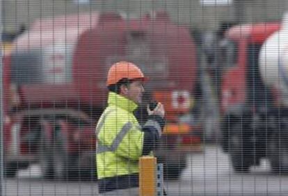 Un operario habla por un "walkie-talkie" mientras unos camiones cisterna esperan para cargar gasolina en el depósito de combustible de Kingsbury, Reino Unido. EFE/Archivo