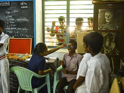 Un médico indio examina el ojo de un escolar durante una campaña de revisión ocular tras el aumento de casos de conjuntivitis vírica u ojo de Madrás, en un colegio, en Chennai (India).