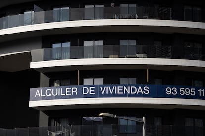 Edificio de pisos en alquiler con un cartel publicitario que los anuncia en la Avenida Carrilet, en Barcelona