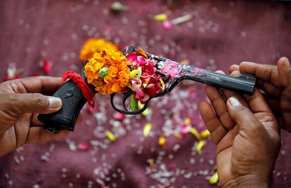 Los oficiales de policía sostienen un revólver mientras ofrecen oraciones a sus armas como parte de un ritual en su cuartel general con ocasión de Dussehra, o Vijaya Dashami, festival en Ahmedabad (India).