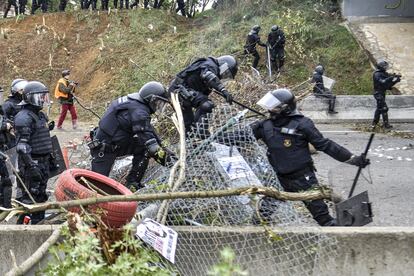 Agentes antidisturbios saltan por una de las barricadas colocadas por los manifestantes durante el corte de la AP-7 en Salt (Girona), este míercoles. 