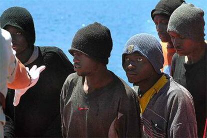 Varios inmigrantes esperan para desembarcar en el muelle de Gran Tarajal (Fuerteventura) tras ser interceptada ayer la embarcación en la que viajaban.
/ EFE
Un subsahariano es ayudado en La Gomera por los equipos de rescate.