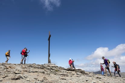 Excursionistas llegan a la cima del Puigmal, a 2.910 metros, donde se sitúa la gran cruz de hierro.