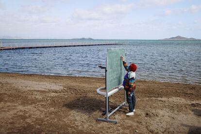 Un profesor imparte clase a los alumnos (no salen en la foto) del colegio Félix Rodríguez de la Fuente en la Playa de los Nietos en Cartagena (Murcia), como parte de un proyecto conocido como 'Aire Limpio'.