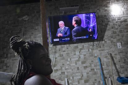 Joyce Encarnacao de Paula, de 13 años, se reúne con su familia para ver el debate presidencial por televisión en Duque de Caxias, estado de Río de Janeiro, Brasil, este domingo.