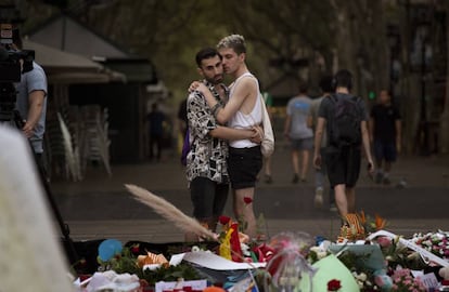 Dos joves davant de l'altar en homenatge a les víctimes a la Rambla de Barcelona.