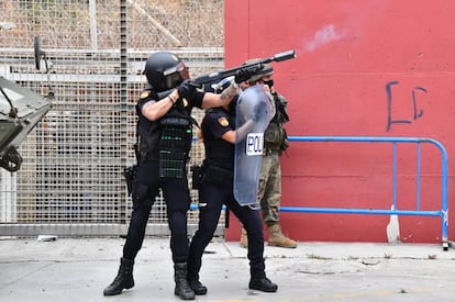 Un agente de la Policía Nacional lanza botes de humo en el perímetro de la ciudad de Ceuta, este martes.