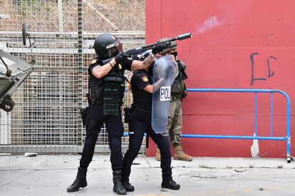 Un agente de la Policía Nacional lanza botes de humo en el perímetro de la ciudad de Ceuta, este martes.