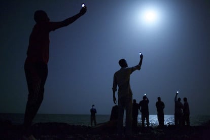 Fotografía titulada "Señal", realizada por el estadounidense John Stanmeyer, que ha ganado el World Press Photo, según informó la organización del prestigioso galardón con sede en Amsterdam (Holanda) mediante un comunicado, hoy, viernes 14 de febrero de 2014. El jurado de la 57 edición del World Press Photo concedió hoy el galardón a la fotografía de 2013 a Stanmayer por su instantánea, en la que un grupo de inmigrantes africanos busca cobertura para sus teléfonos móviles en la orilla de Yibuti.