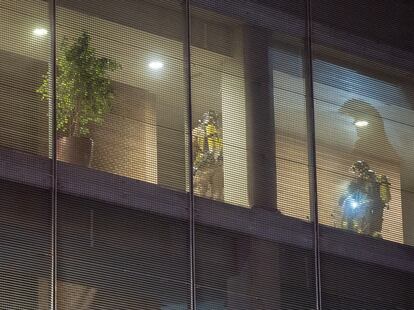 Una pareja de bomberos inspecciona el interior de la residencia de ancianos.