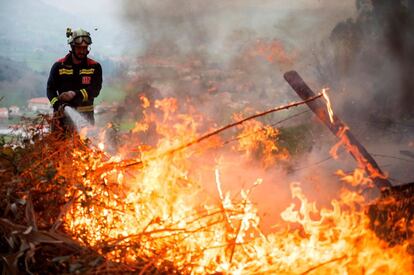 Un efectivo del Cuerpo de Bomberos del 112 de Cantabria durante las labores de extinción de un incendio forestal próximo a la localidad de Aes.