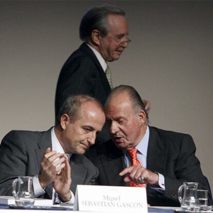 El rey Juan Carlos conversa con el ministro de Industria, Miguel Sebastián, en la asamblea anual de la Fundación COTEC en Madrid.