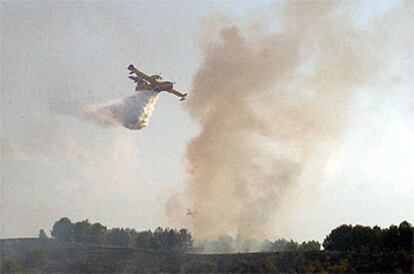 Un hidroavión descarga agua en el incendio del parque regional del Manzanares.